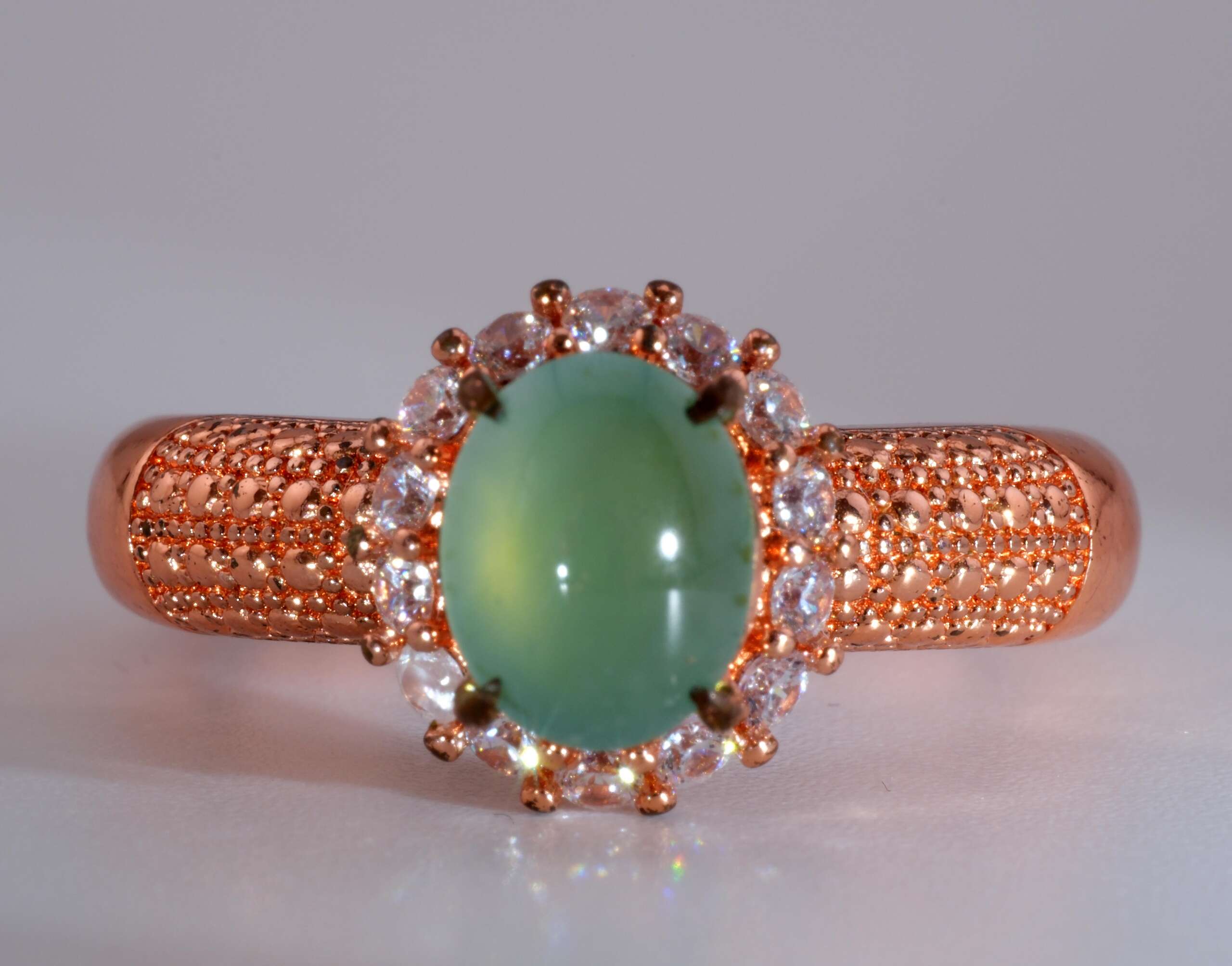 Front view of Type-A jadeite jade ring with light apple-green cabochon and rose-gold pavé band, size 8