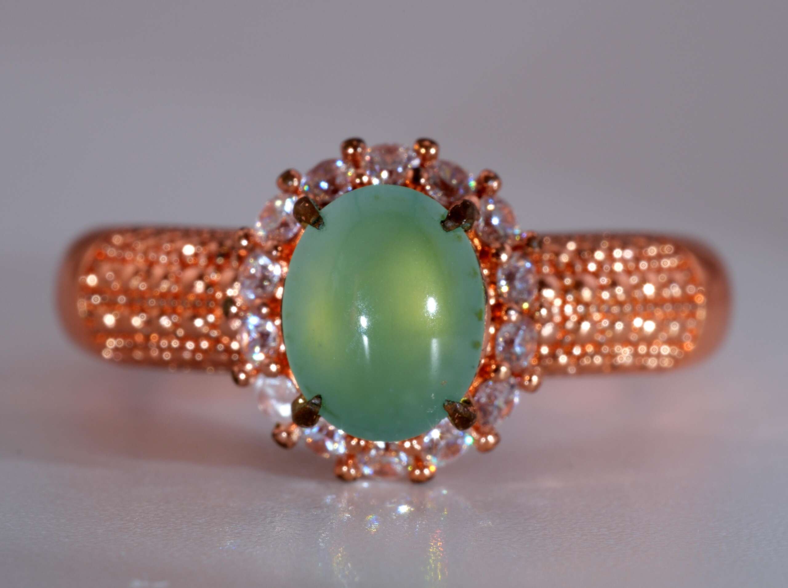 Front view of Type-A jadeite jade ring with light apple-green cabochon and rose-gold pavé band, size 8